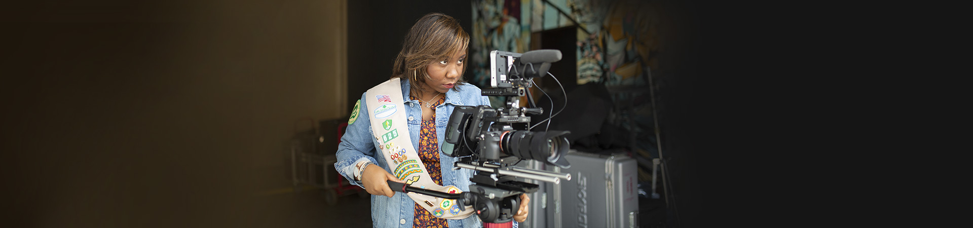  Ambassador Girl Scout operating a professional-looking movie camera on a tripod 