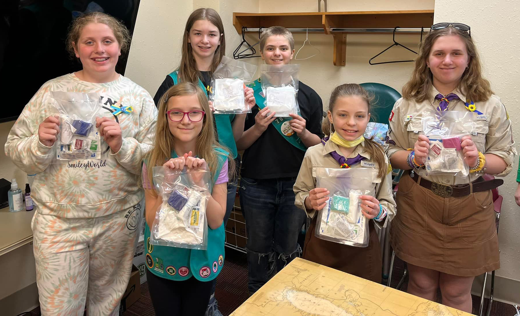 Junior Girl Scout troop holding first aid kits 