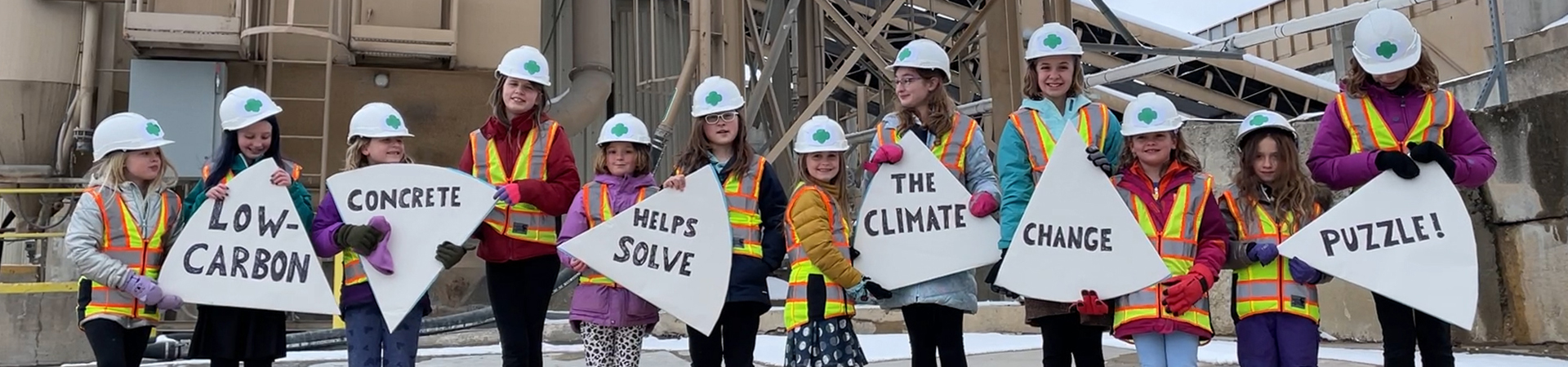  girls holding signs and wearing hardhats 