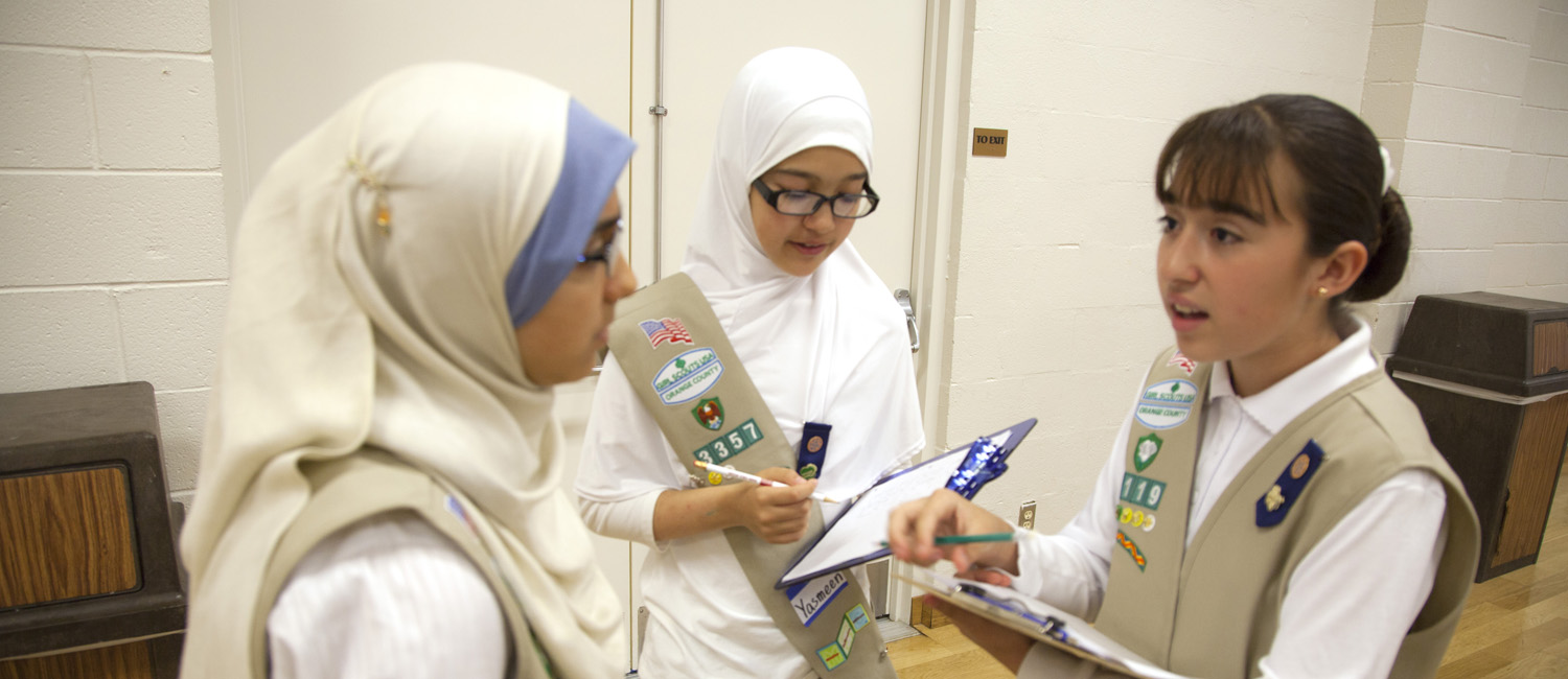 Dana (right) getting organized to start the event with fellow Girl Scouts Ameerah (left) and Yasmeen (center).