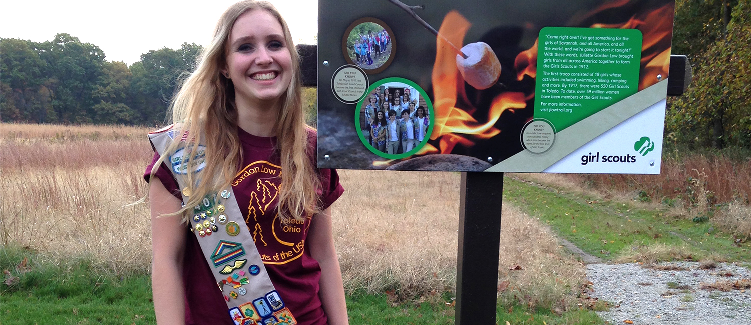  Ellie Leonard smiles big by the sign she made for the first-ever official Girl Scout hiking trail  
