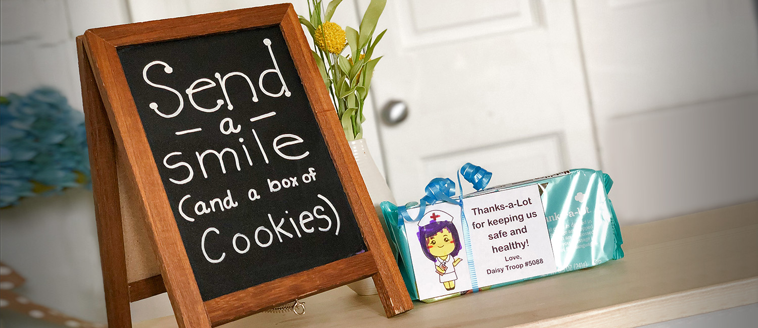  chalkboard that reads "Send a Smile (and a box of cookies) next to a package of thanks-a-lot cookies 