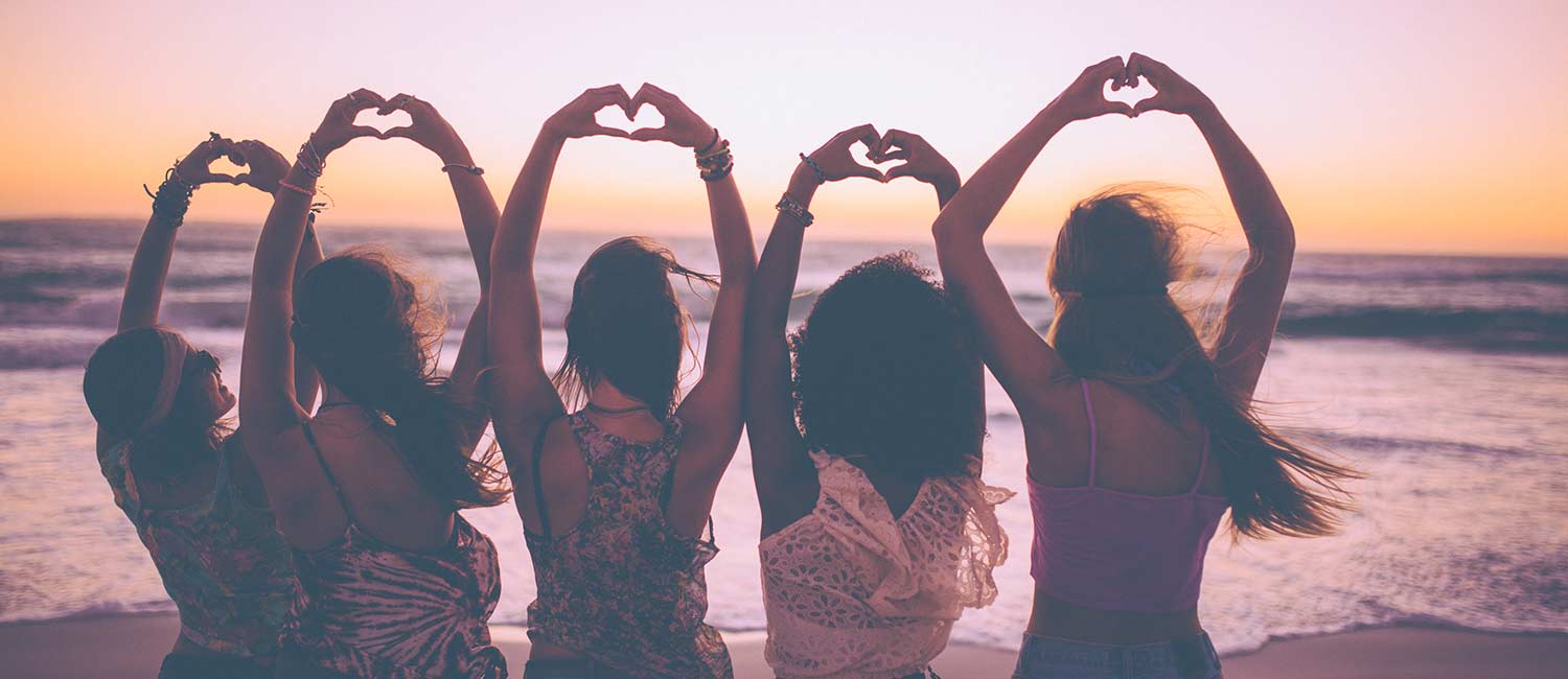  Five girls celebrating Galentine's Day and friendship at the beach. 