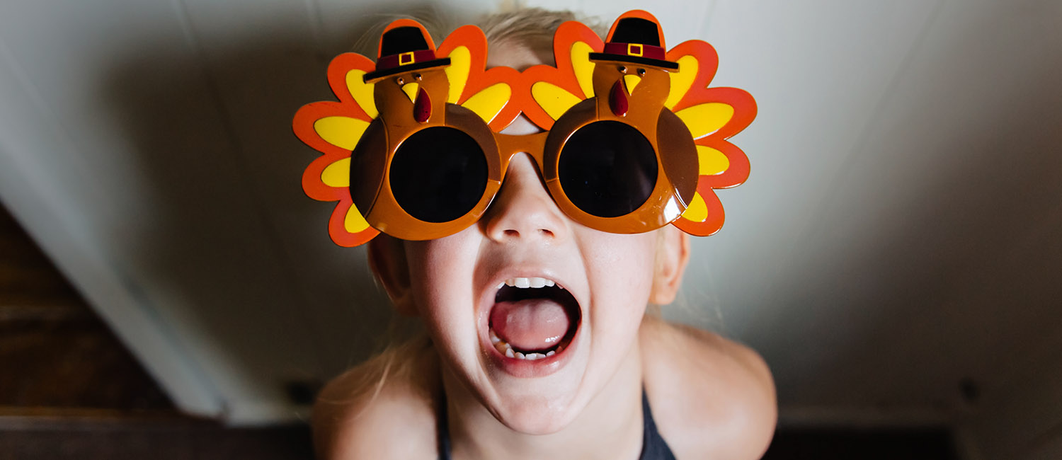  Toddler girl wearing Thanksgiving turkey sunglasses. 