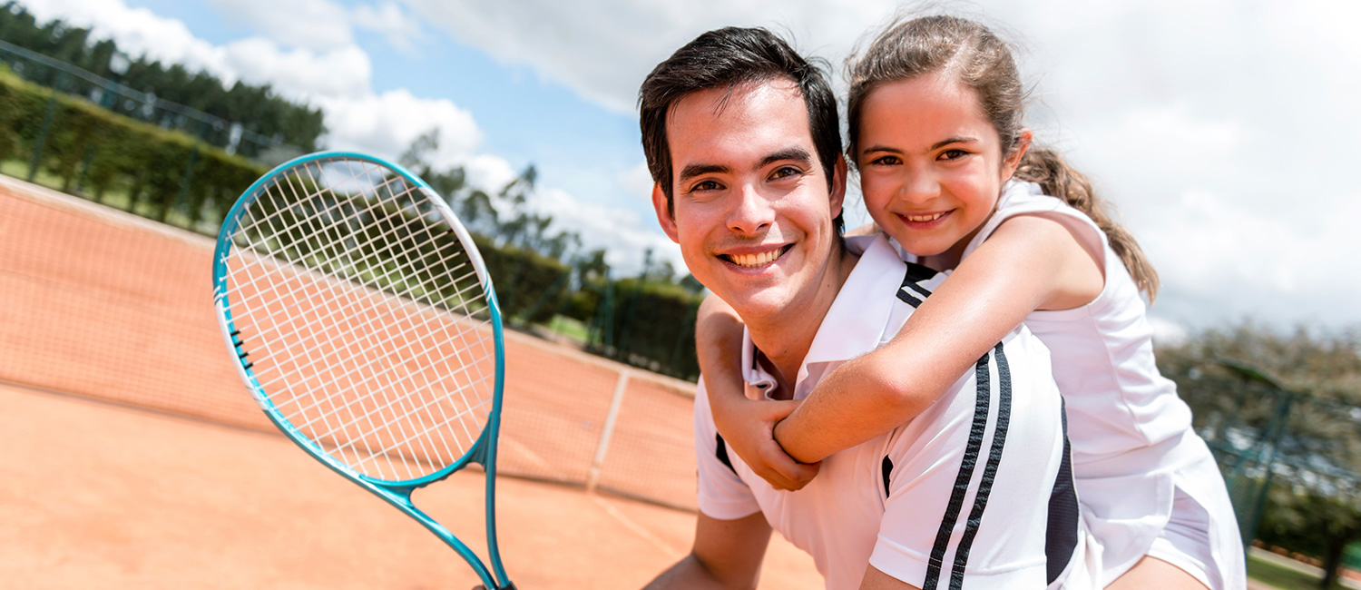  Healthy dad and young daughter on tennis court. 