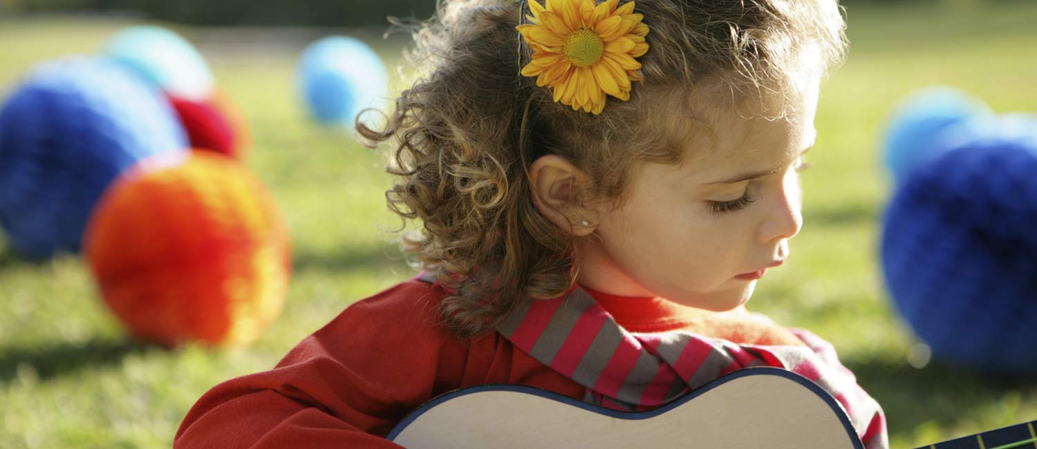  Little girl learning how to play guitar. 