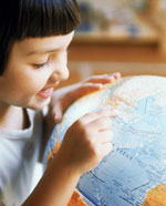 Photo of a girl looking at a globe. (Photonica)