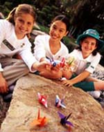 Photo of three Girl Scouts showing off their origami. &copy; GSUSA. All rights reserved. (Photographer: Lori Adamski-Peek)