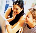 Photo of two women looking at computer screen. (Zefa Fast Forward/Photonica.)