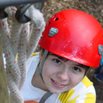 Photo of a girl with red helmet climbing on rope. (Photo credit: Melinda Baxter)