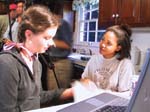 Photo of two Girl Scouts talking in front of a computer. (Courtesy of Cahaba Girl Scout Council)