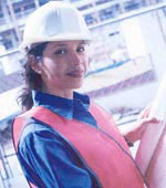 Photo of a woman wearing a hardhat with engineering plans.