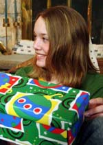 Photo of a girl holding a wrapped gift.