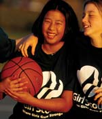 Photo of two Girl Scouts holding a basketball.