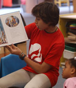 Photo of a Girl Scout volunteer reading to Girl Scouts. &copy; GSUSA. All rights reserved.