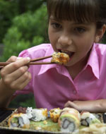 Photo of a girl eating sushi. &copy; GSUSA. All rights reserved. (Photographer: Quad Photo/Karineh Gurjian-Angelo/Dedjora Von Jutaz)