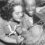 Photo of two women examining a bird's nest, circa 1947. &copy; GSUSA. All rights reserved.