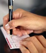 Photo of a person writing a check.