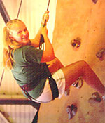 Photo of a girl rock-climbing indoors.