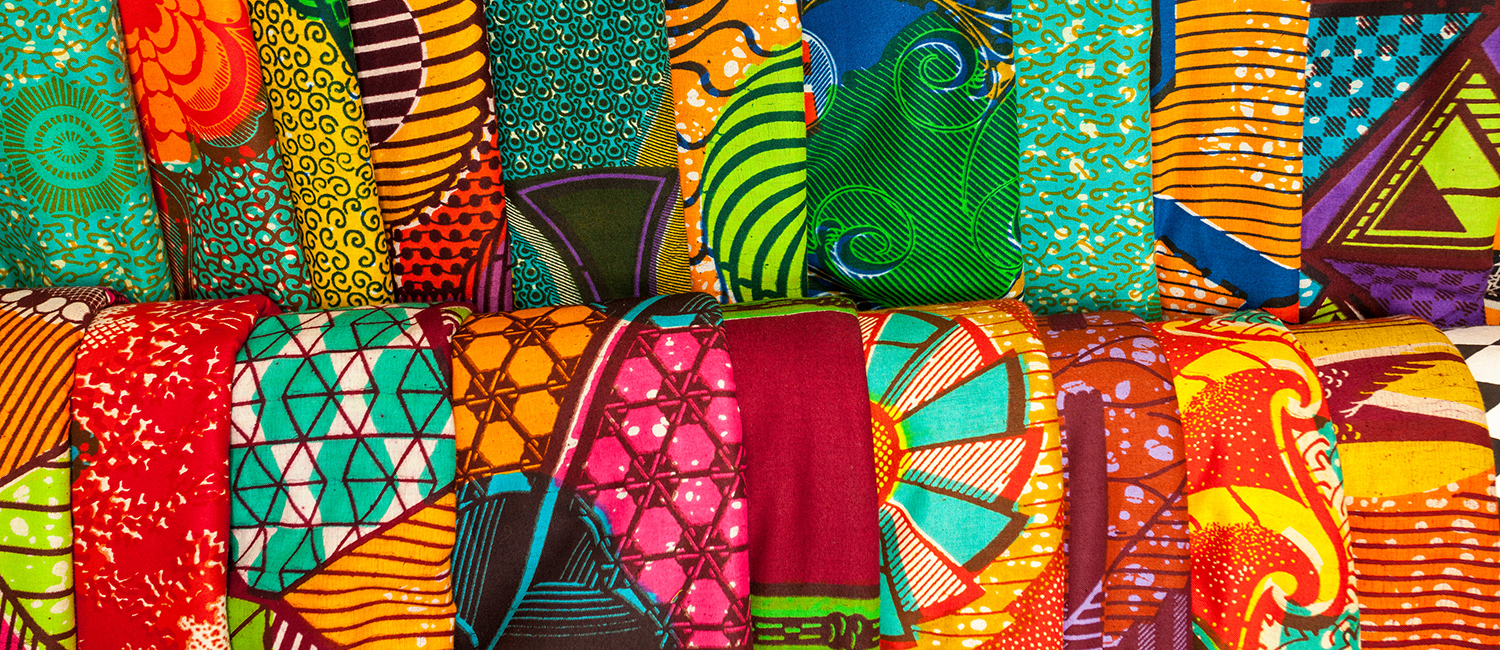 pile of folded brightly-colored textiles 