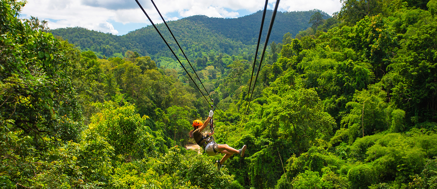 a girl zip lining in the jungle