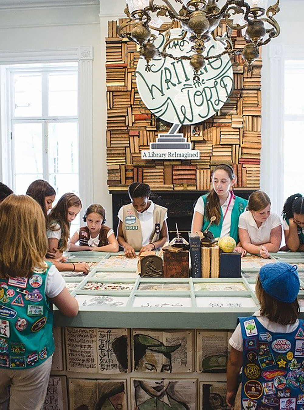 A group of Girl Scouts examine Girl Scout artifacts.