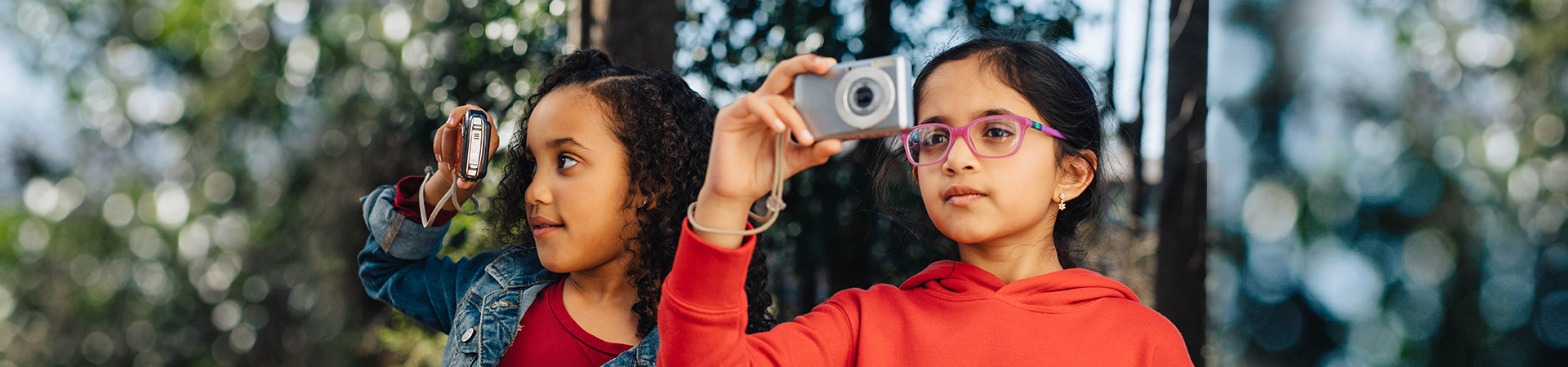  two girls on a hike taking pictures with small digital cameras 