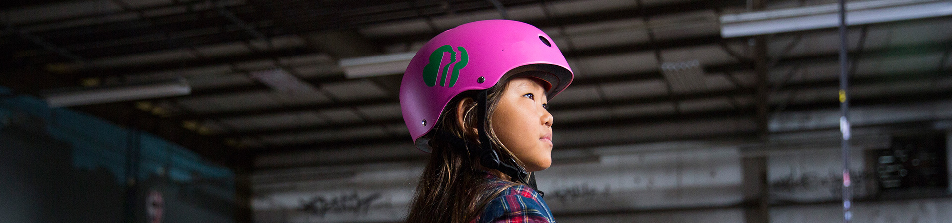  side profile of a Girl Scout wearing a hot pink helmet  
