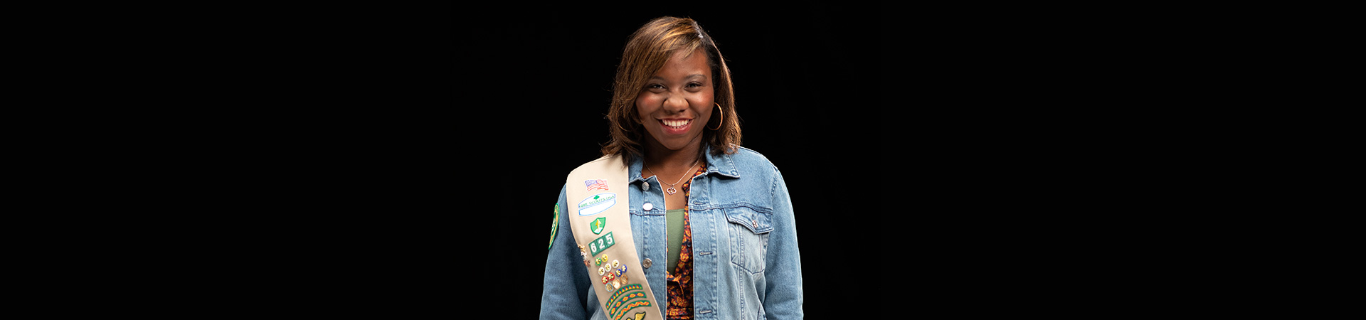  Gold Award Girl Scout in front of a black background 