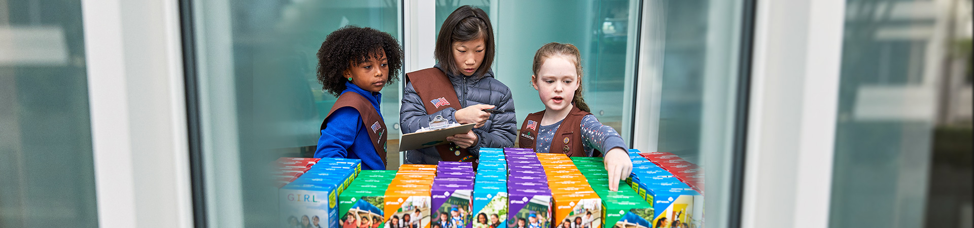  three Brownie Girl Scouts at a cookie booth 