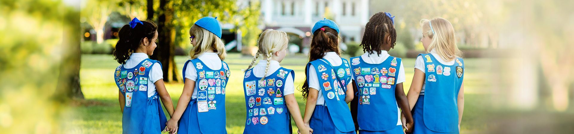 Group of Daisy Girl Scouts  holding hands outdoors 