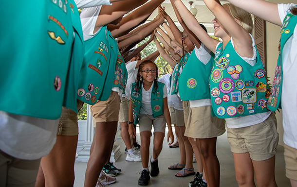 Group of junior middle school Girl Scouts wearing sashes and badges playing games outdoors