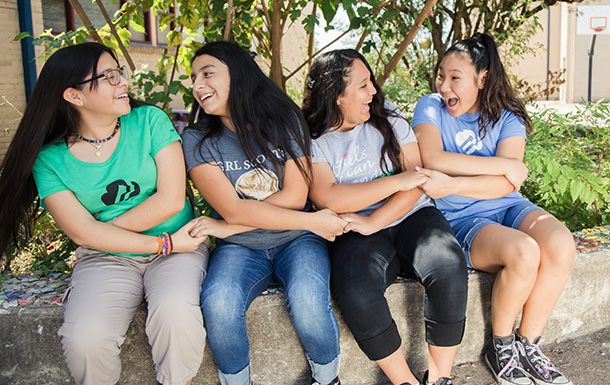 Group of Senior Girl Scouts sitting in a friendship handshake and smiling 