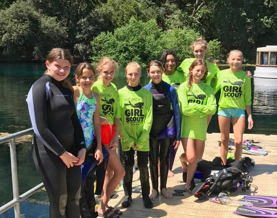 Scuba troop poses on dock before dive. 