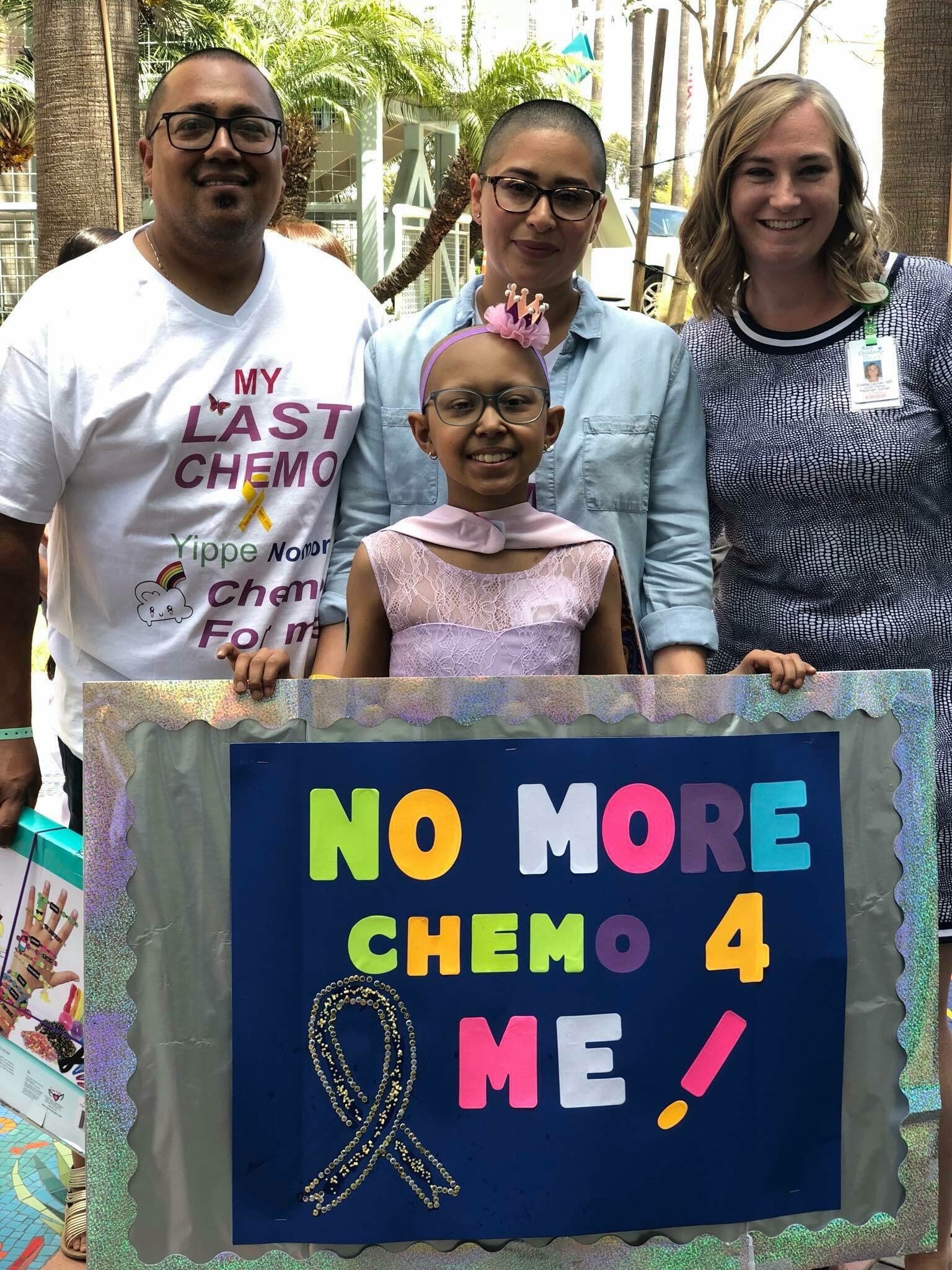 Sarah proudly displays "NO MORE CHEMO 4 ME!" sign