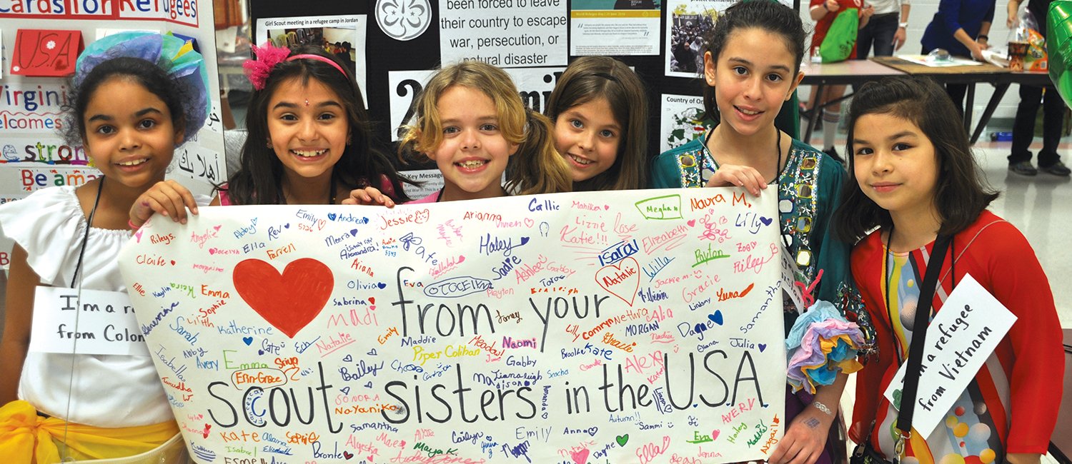 Girls hoding a banner that reads "love from your Girl Scout sisters in the USA"