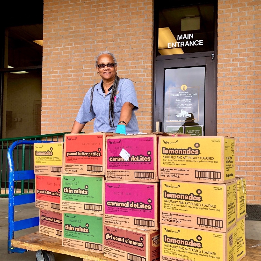hospital staff with a cart loaded with cases of girl scout cookies