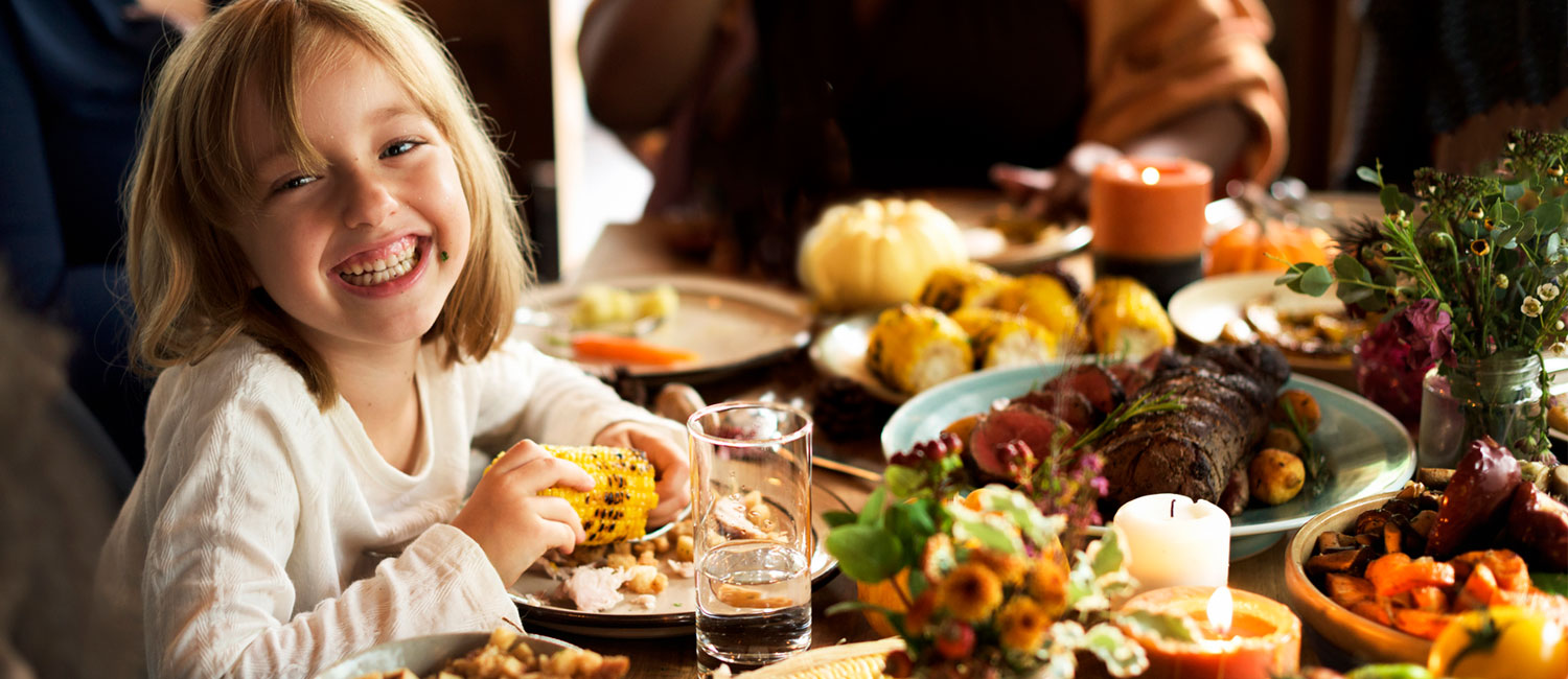  A girl is enjoying family Thanksgiving dinner with her family. 