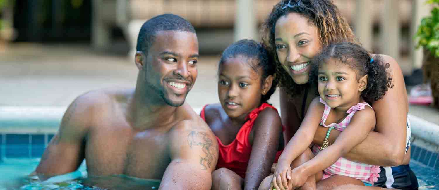  Family with their two girls in a swimming pool. 
