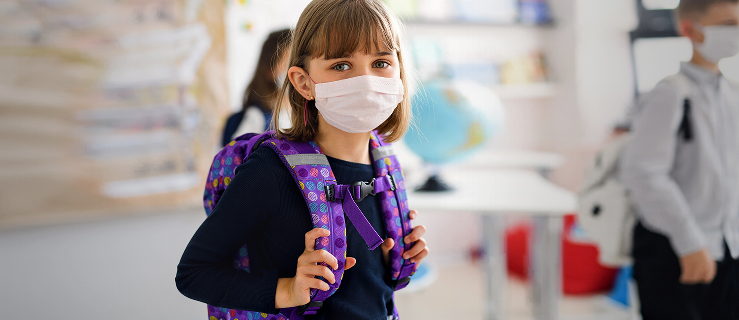  girl wearing a face mask and purple backpack looking scared and worried going back to school 