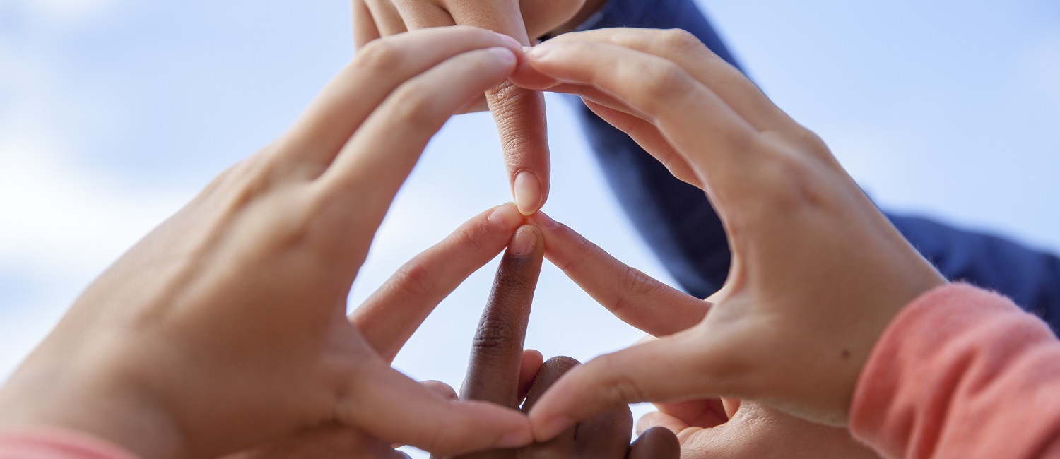  A group of girls making a peace sign shape with their fingers 
